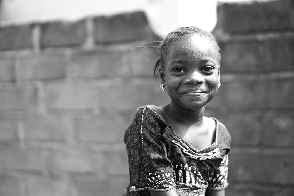 Smiling African Girl With a Wet Face After Having Taken A Sip From The Water Borehole